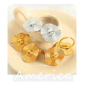 Detailed view of 18K gold and silver textured wave earrings and adjustable ring set