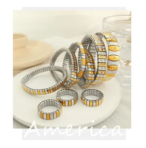 Macro shot of two-tone stretch bracelets and rings with crystal inlay on marble base