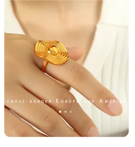 Close-up of golden wavy textured round ring with irregular oval face on finger