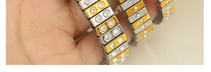 Detailed macro view of two-tone gold and silver metal bracelet with inset rhinestones