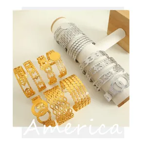 Close-up of gold and silver textured hollow cuff bracelets on a jewelry display stand