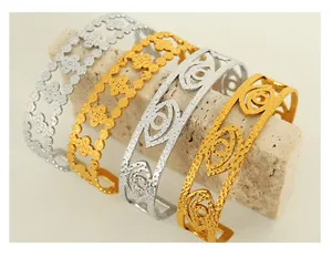 Detail of 18K gold and silver textured cuff bracelets with clover and eye cutout patterns