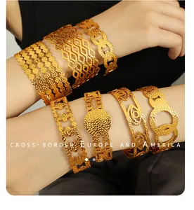 Detailed view of layered 18K gold plated steel bracelets featuring evil eye and cutout motifs