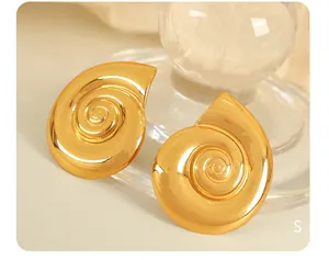 Primer plano de pendientes de caracol en titanio chapado en oro con texturas en espiral