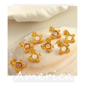 Detailed shot of vintage gold flower earrings with pink and white cat eye stones