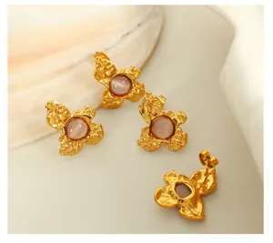 Detailed shot of gold irregular flower earrings with purple cat eye stones