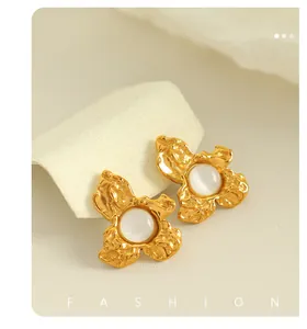 Macro detail of French vintage gold flower stud earrings with hammered metal texture