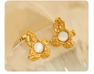 Macro view of gold flower earrings with moonstone center and hammered metal texture