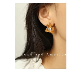 Close-up of vintage gold flower earring with a round mother-of-pearl center stone