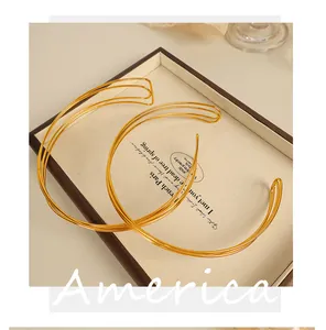 Close-up of minimalist layered gold wire open choker necklace on a vintage display plate