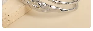 Detailed close-up of a silver-toned hammered metal bracelet with organic molten texture