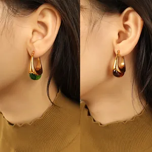 Minimalist U-shaped gold earrings with green and amber teardrop resin pendants