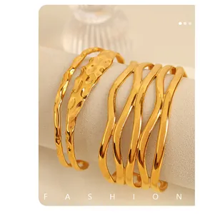 Detailed view of 18K gold plated hammered texture and wavy cutout cuff bracelets.