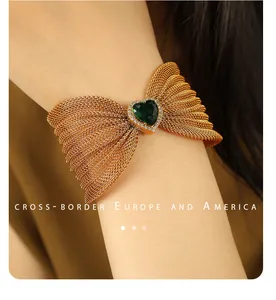 Primer plano de la pulsera de malla dorada con piedra verde de corazón y cristales
