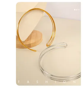 Detail of minimalist triple-layer metal collars in polished gold and silver finishes