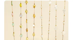 Gros plan de bijoux en coquillage doré avec breloques irisées d'étoiles et de trèfles