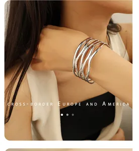 Close-up of a wide hollow wavy multi-layer polished silver-tone bangle bracelet