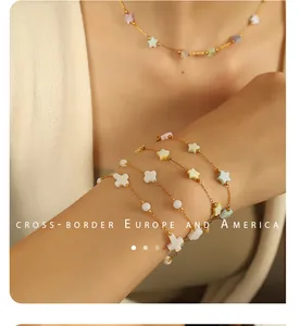 Détail d'un ensemble de bijoux en coquillage doré avec breloques étoile et croix