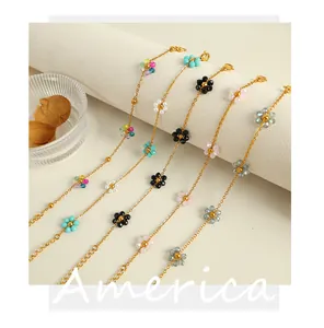 Detail of five 18k gold plated floral bead bracelets arranged on white velvet roll