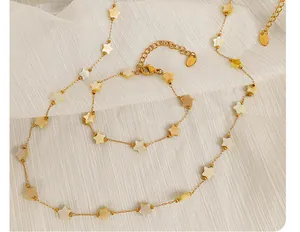 Gros plan d'un ensemble collier et bracelet en acier doré avec pendentifs étoiles