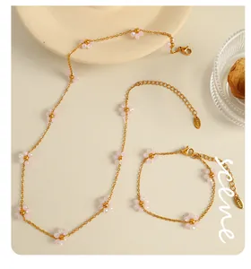 Macro detail of 18k gold plated stainless steel chain with pink floral beaded charms