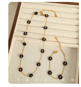 Detail of 18k gold plated titanium steel necklace and bracelet set with black crystal flowers