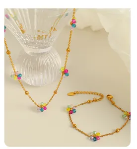Detail of 18k gold plated titanium necklace and bracelet set with colorful crystal flowers