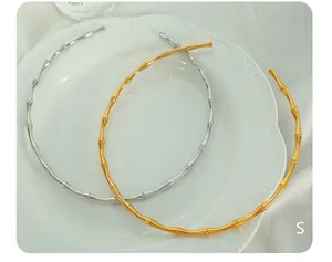 Detail der Bambus-Glieder-Halskette in 18K Gold und Silber auf Porzellan
