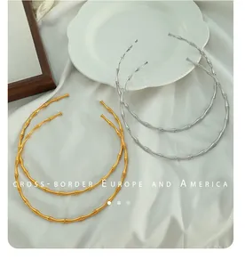 Makro-Detail der 18K vergoldeten Bambustextur auf einem Edelstahl-Halsring für Damen