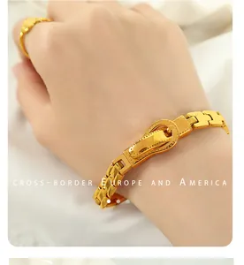 Detail eines vergoldeten Gürtelschnallen-Armbands und passenden Rings am Handgelenk