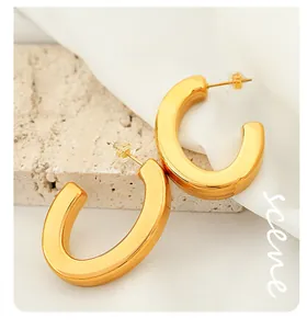 Detailed view of chunky C-shape hoop earrings in 18K gold plated mirror finish