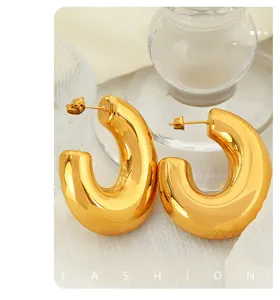 Detailed macro shot of 18K gold plated C-shaped hoop earrings with a mirror-polished finish