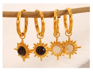 Detail view of 18K gold plated sunburst earrings with cat eye and black stone inlays
