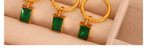 Close-up of 18K gold-plated hoop earrings with green rectangular gemstone charms