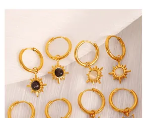Macro view of 18K gold plated sunburst earrings with opal stones on white texture