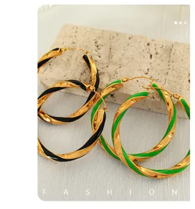Dettaglio di orecchini a cerchio intrecciati in oro con finitura in smalto colorato