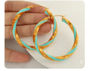 Dettaglio orecchini a cerchio a spirale in smalto azzurro e metallo dorato intrecciato