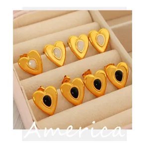 Detailansicht der goldenen Herzohrringe mit schwarzen und weißen Edelsteinen in einer Box