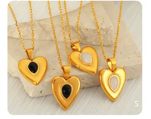 Detail von 18k Gold Herz Halsketten mit schwarzen und weißen Edelsteinen auf Stein