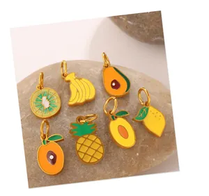Macro detail of tropical fruit charms with colorful enamel finish on natural stone background