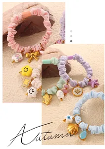 Detail of colorful scrunchies with golden bow and mixed charms on textured stone