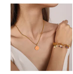 Detail of gold basketball necklace and charm bracelet with colorful enamel pendants