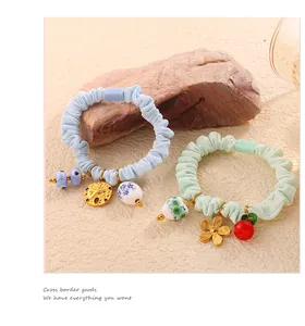 Detail of light blue and green scrunchies with starfish and floral porcelain charms