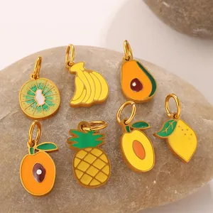Set of 7 colorful tropical fruit enamel pendants with golden hooks on a natural stone