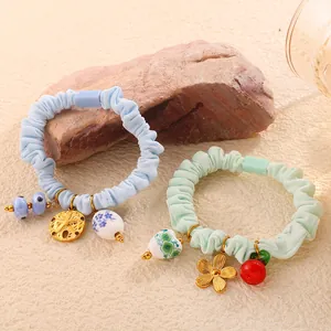 Set of two pastel elastic scrunchies featuring floral heart and ceramic bead charms