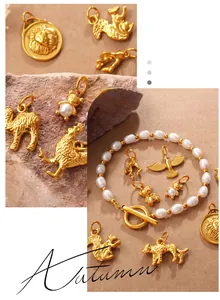 Detalle de colgantes de animales dorados y pulsera de perlas barrocas con cierre en T