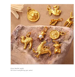 Disposición artística de colgantes de animales dorados sobre piedra texturizada, león y ciervo