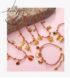 Braided red and pink bracelets with gold flower, heart and butterfly charms on stones