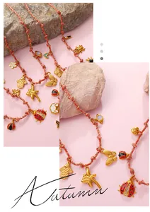 Detail of woven necklace with gold butterfly, ladybug, and flower charms in autumn style