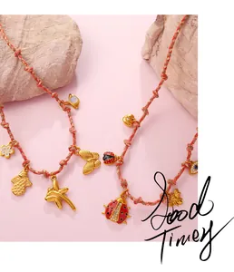 Detail of colorful woven necklace with gold ladybug, heart and evil eye pendants